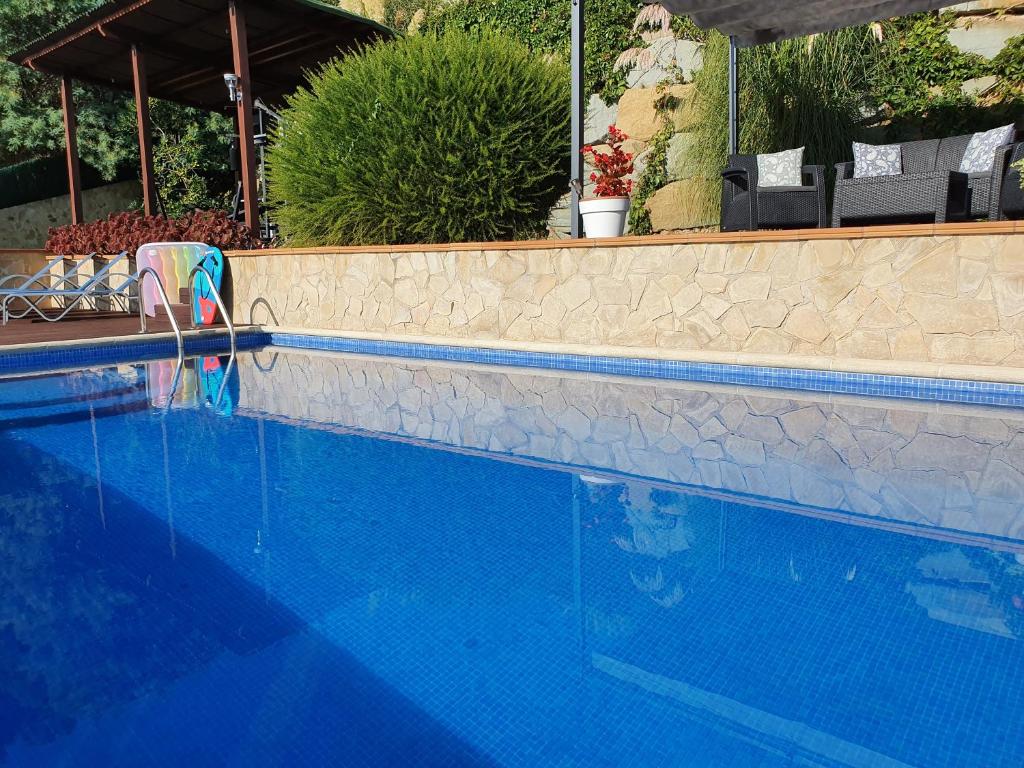 a blue swimming pool with a chair next to it at Villa SportLife in Lloret de Mar