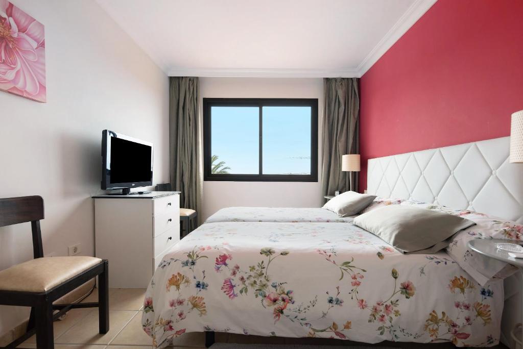 a bedroom with a bed and a red wall at Trevina 31-2 in Puerto de la Cruz