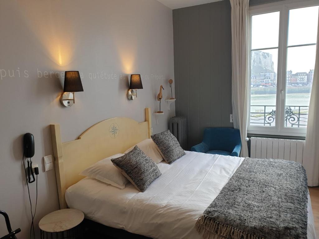 een slaapkamer met een groot wit bed met een raam bij The Originals Boutique, Hôtel La Villa Marine, Le Tréport in Le Tréport