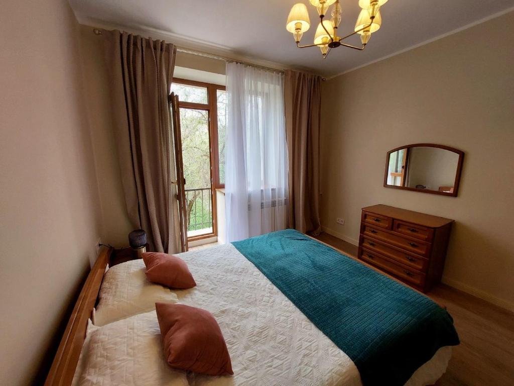 a bedroom with a bed with a mirror and a window at Квартира в самом центре in Almaty
