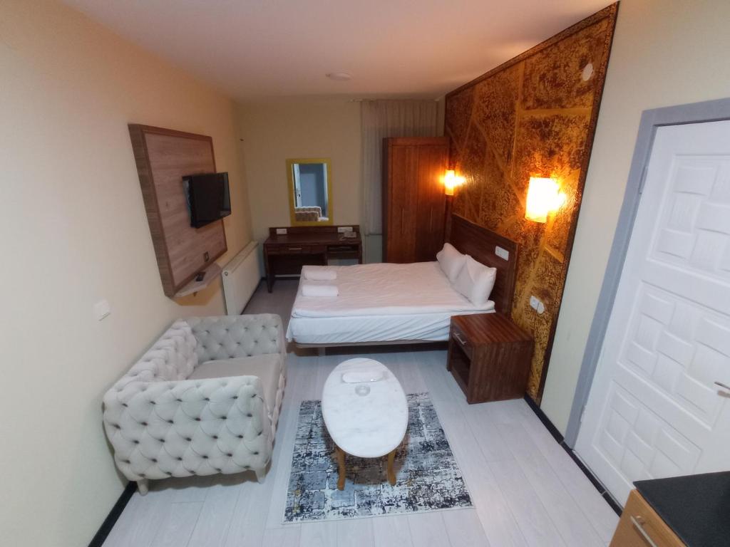 a hotel room with a bed and a couch at MİLENYUM HOUSE SUİT in Ankara