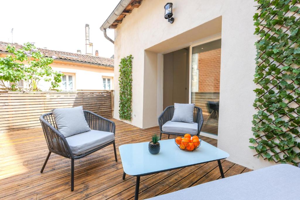 eine Terrasse mit 2 Stühlen und einem Tisch mit Orangen darauf in der Unterkunft LA FABRIQUE #Hyper Centre #Baby foot #Terrasse in Cognac