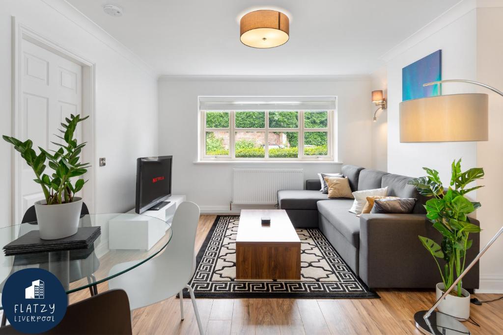 uma sala de estar com um sofá e uma mesa em FLATZY - Quiet Sefton Park Luxury Apartment em Liverpool