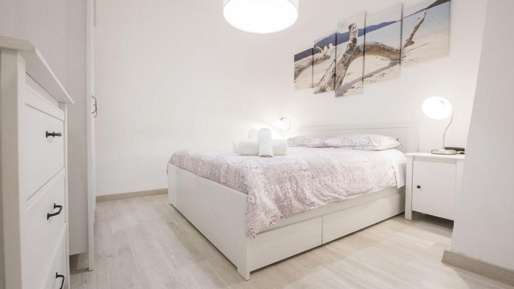 A bed or beds in a room at La Casa Púrpura - Apartamentos Aloha Toledo