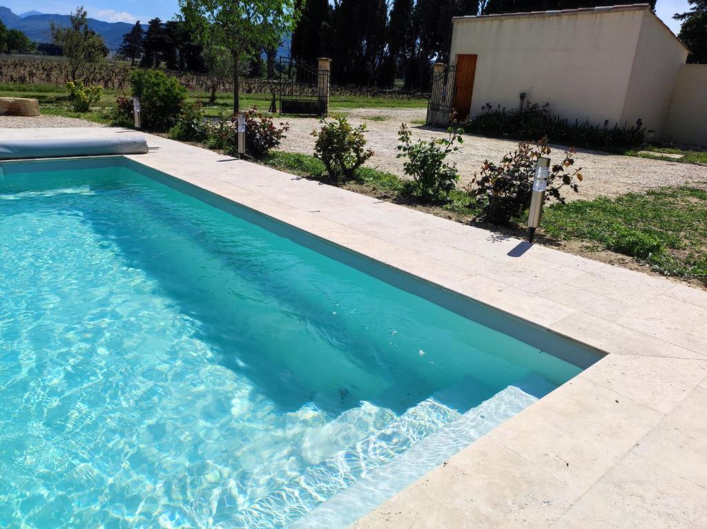 a swimming pool with blue water in a yard at 926 Chemin de Saint-Antoine in Violès