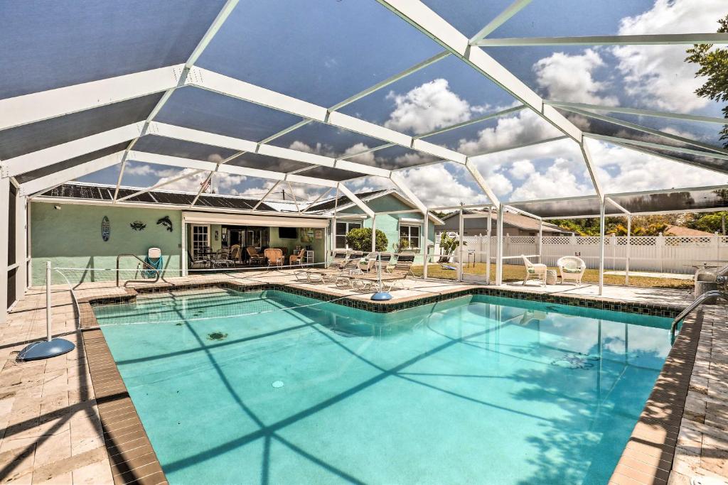 a swimming pool with a roof over it at Colorful Cape Coral Retreat with Screened Lanai! in Cape Coral