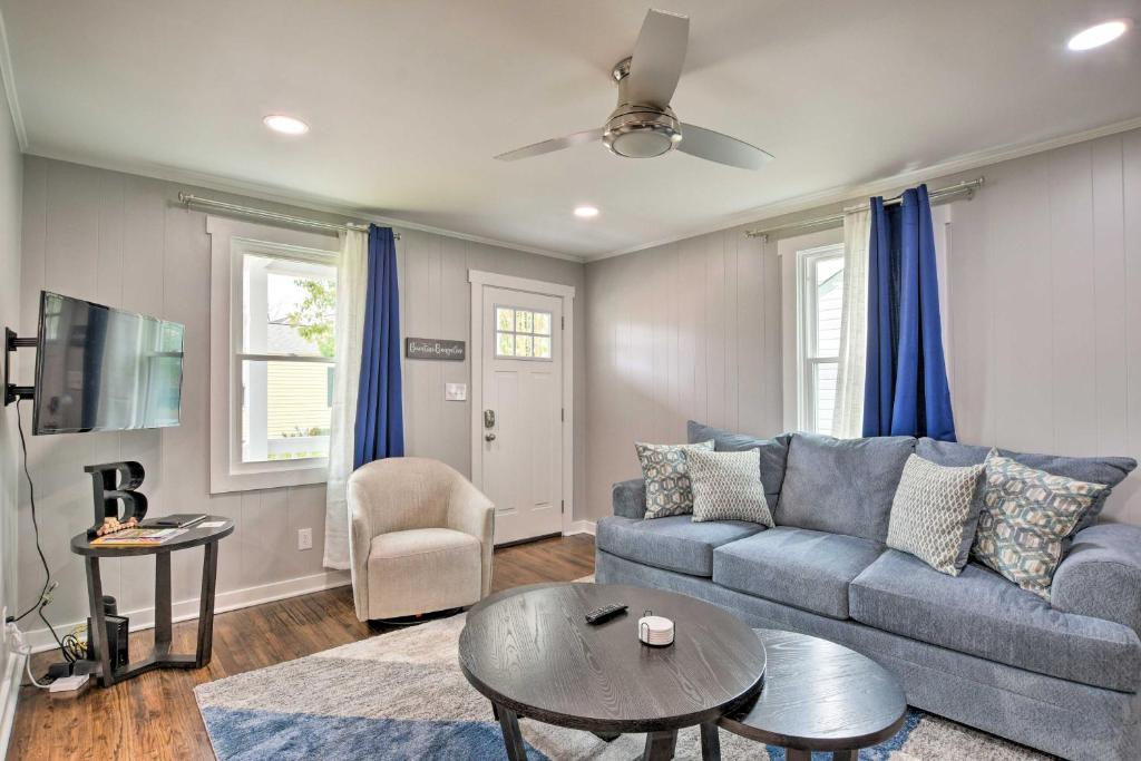 Una sala de estar con un sofá azul y una mesa. en Cozy House with Private Yard, Close to Downtown, en Greenville
