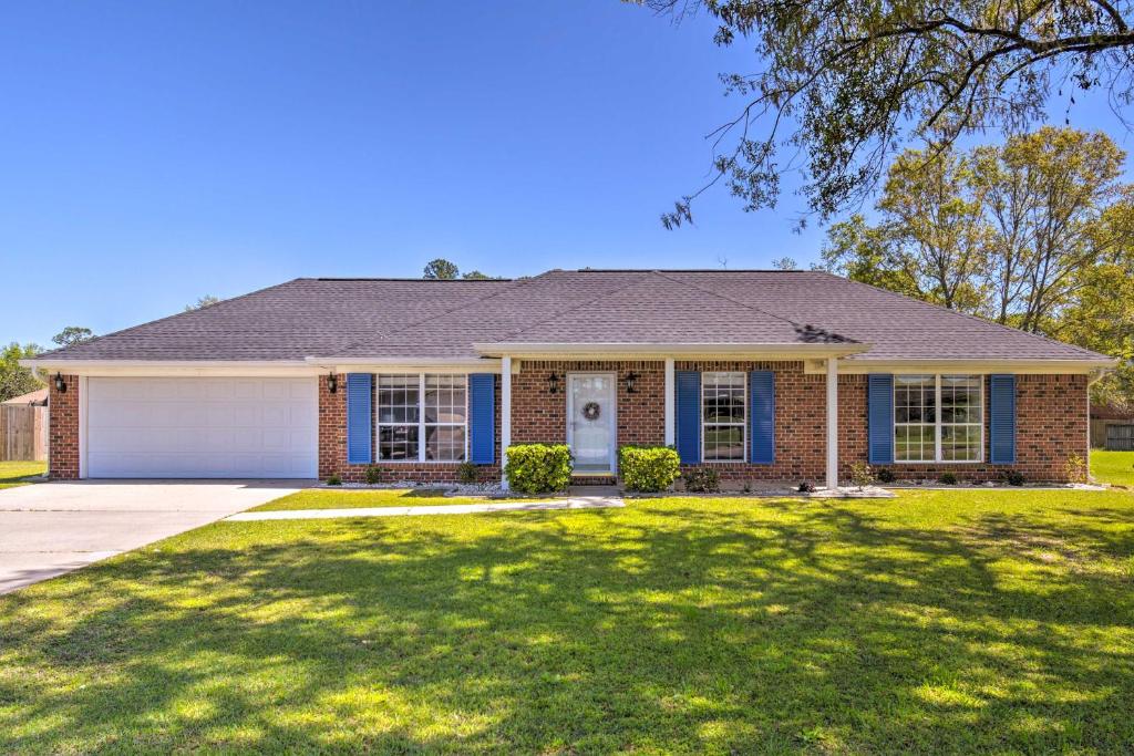 a brick house with a large lawn in front of it at Family-Friendly Foley Getaway with Fenced Yard! in Foley