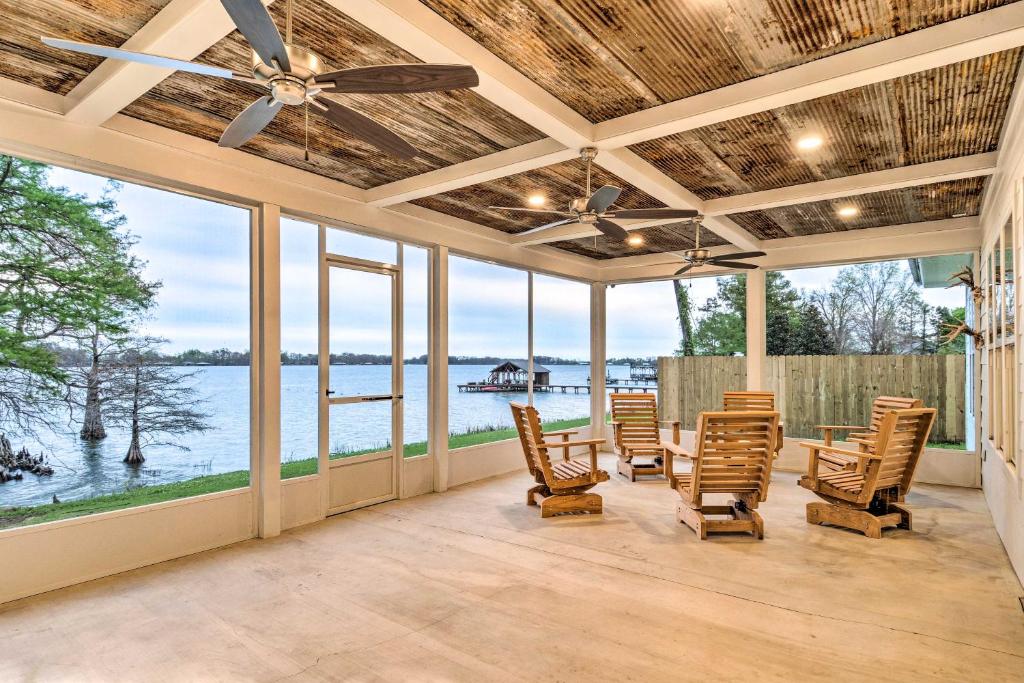 a screened porch with chairs and a view of the water at Modern Lake House on Lake Bruin Pier and Boat Slip! 