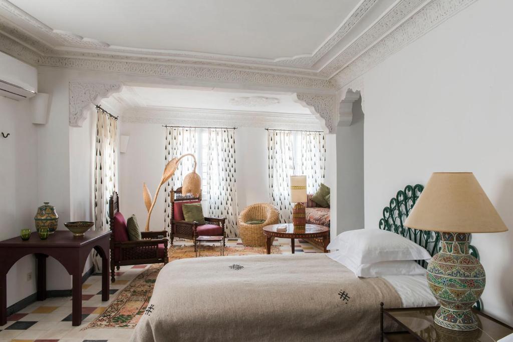 a bedroom with a bed and a living room at Riad Jardin Des Biehn in Fez