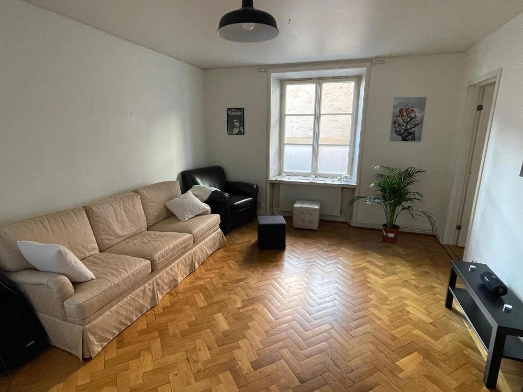 Apartment in Stockholm, 48m2 in Mariatorget Södermalm في ستوكهولم: غرفة معيشة مع أريكة وكرسي