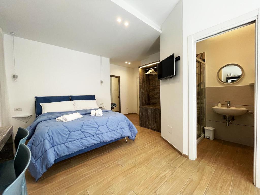 1 dormitorio con cama con edredón azul y lavamanos en Sunny House en Sorrento