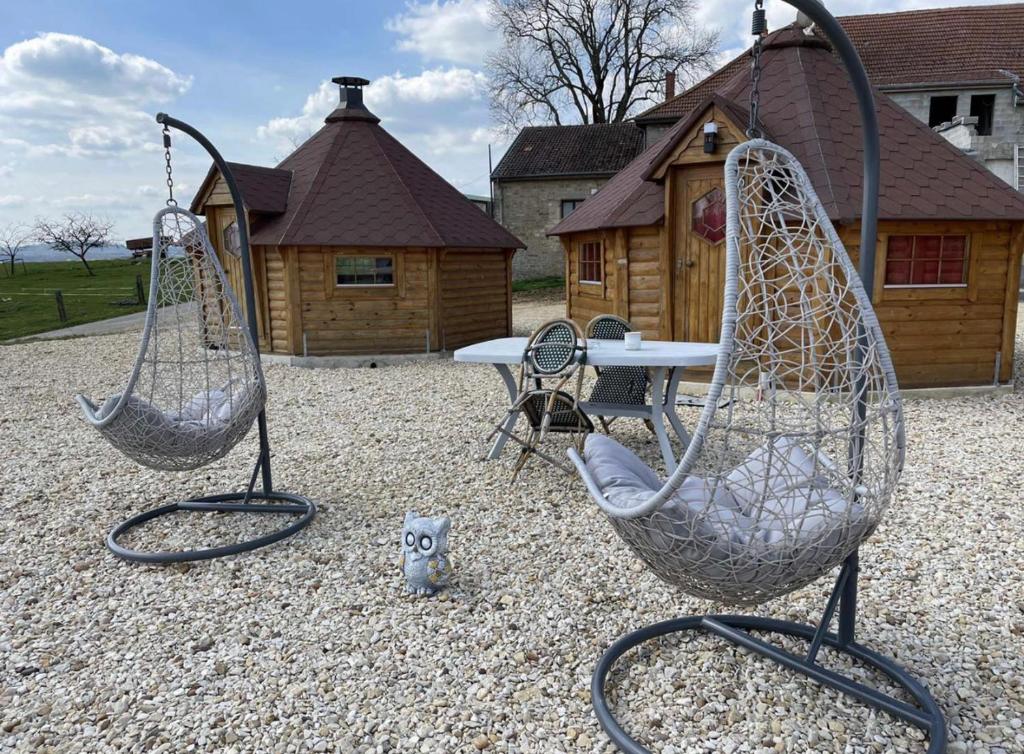 due dondoli e un tavolo in un cortile di Kota à la ferme a Beaumont-en-Argonne