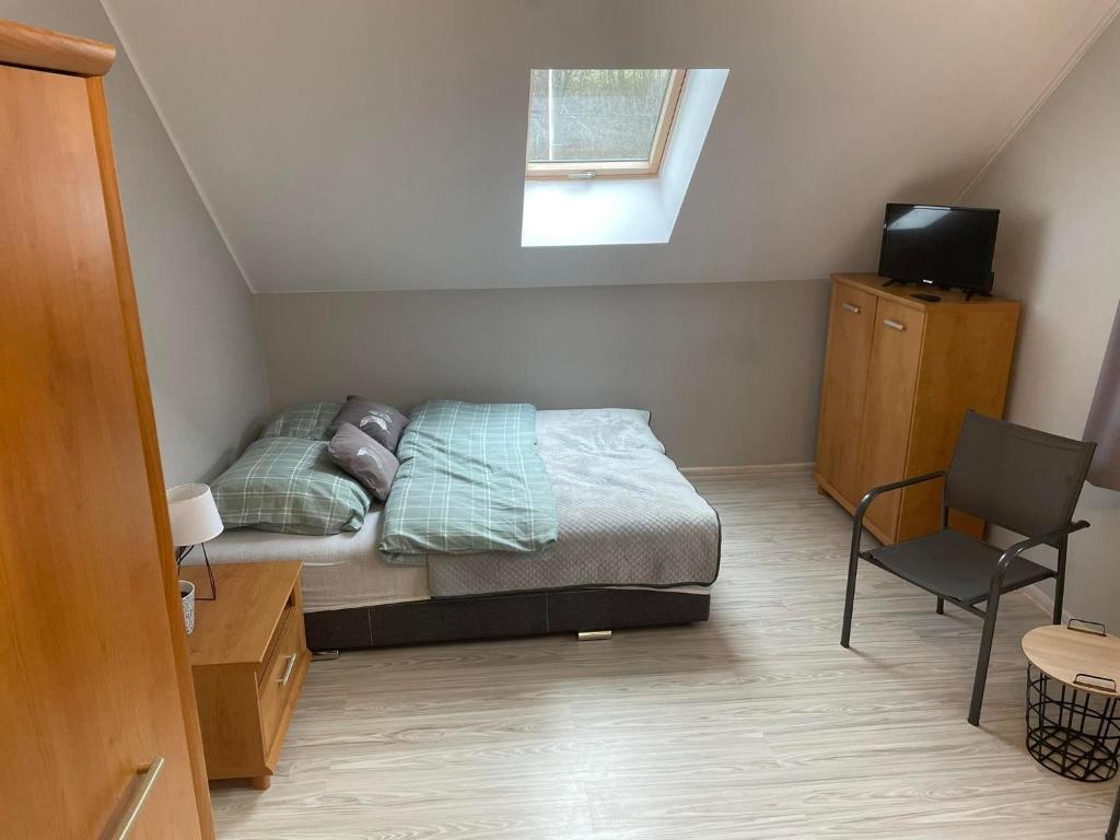 - une petite chambre avec un lit et une chaise dans l'établissement Maciejówka, à Grywałd