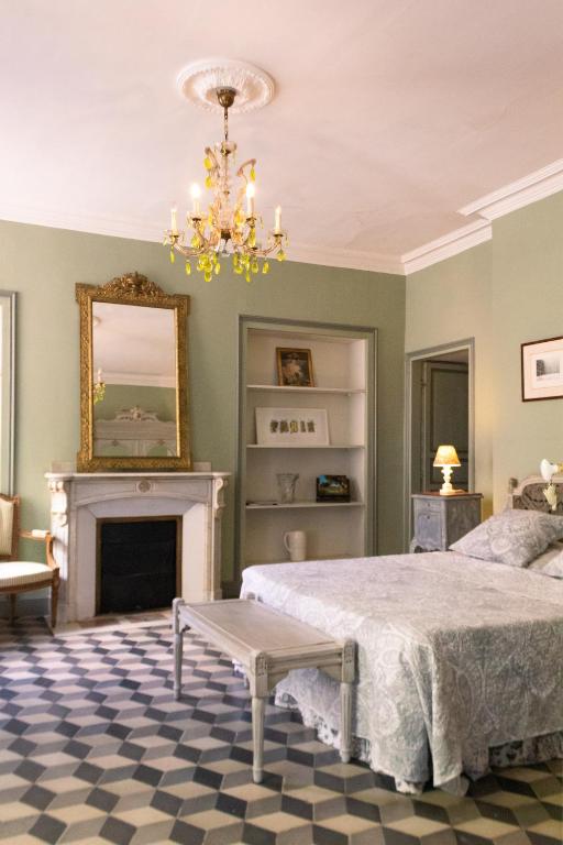 une chambre avec un lit et une cheminée dans l'établissement Le Chai de Marguerite, à Peyriac-Minervois