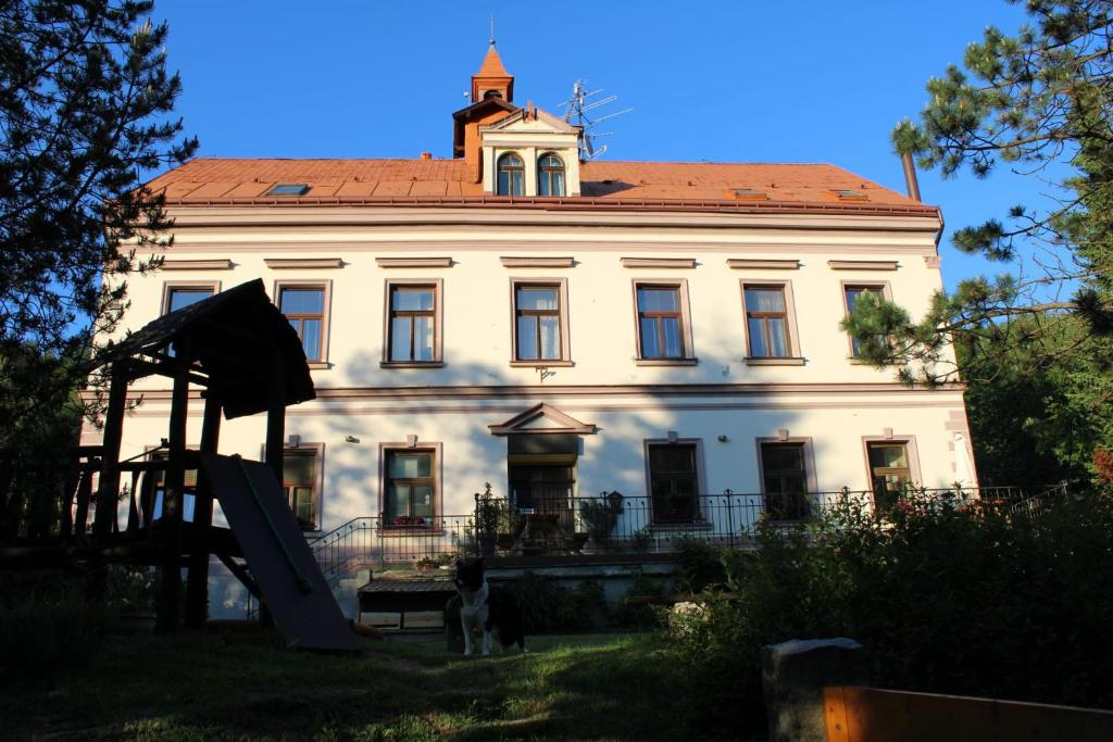 un gran edificio blanco con una torre encima en Penzion Rudolf, en Liberec