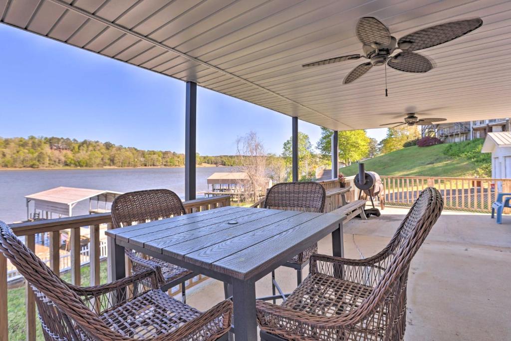 Lakefront Abode with Dock about 15 Mi to Talladega! في Lincoln: طاولة وكراسي خشبية على شرفة مع مروحة سقف