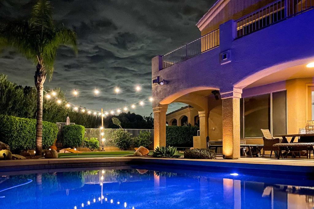 a house with a swimming pool at night at Fountain Hills Home with Pool, Spa and Putting Green! in Fountain Hills