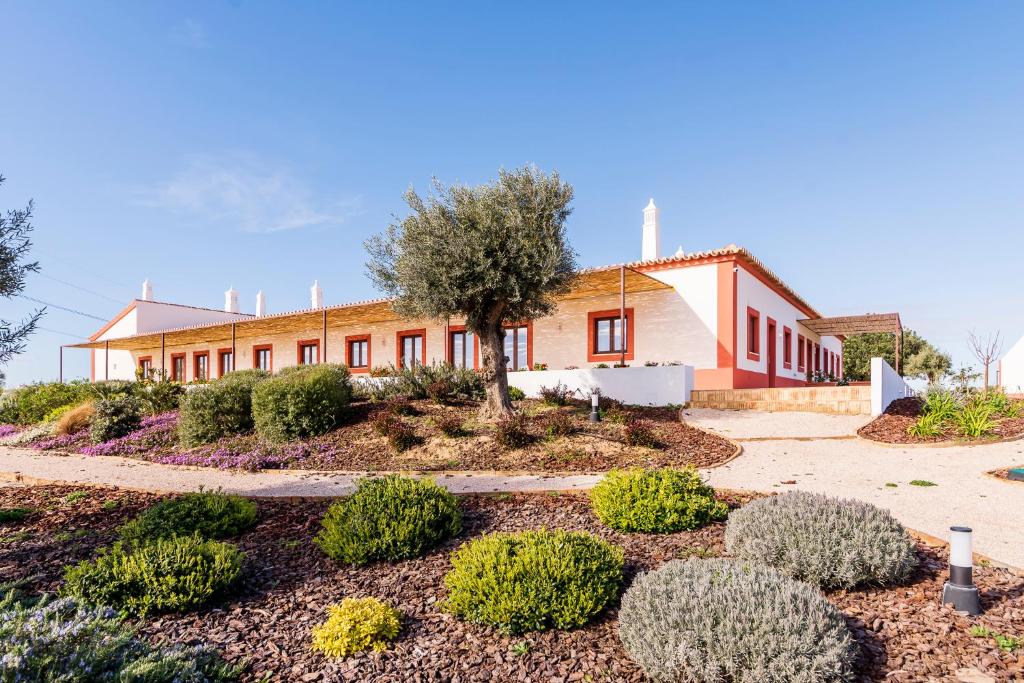 um edifício com um jardim em frente em Quinta da Baleeira em Tavira