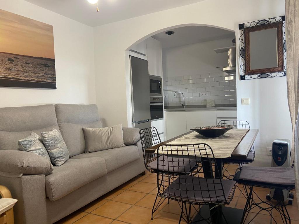 a living room with a couch and a table and chairs at APARTAMENTO RURAL CASA MONTE in Cazalla de la Sierra