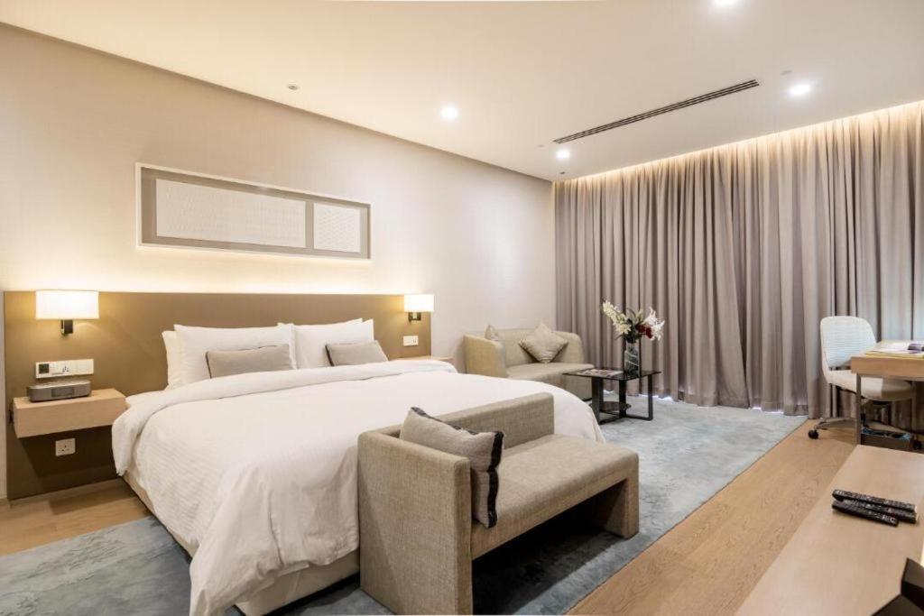 a bedroom with a large white bed and a chair at 188 suites klcc by Signature Apartment in Kuala Lumpur