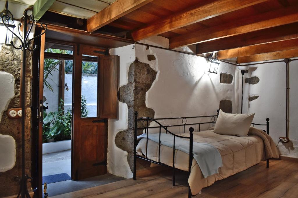 1 dormitorio con 1 cama en una habitación con techos de madera en CASA MAMA LOLA-CA'PEÑATE, en Tenteniguada
