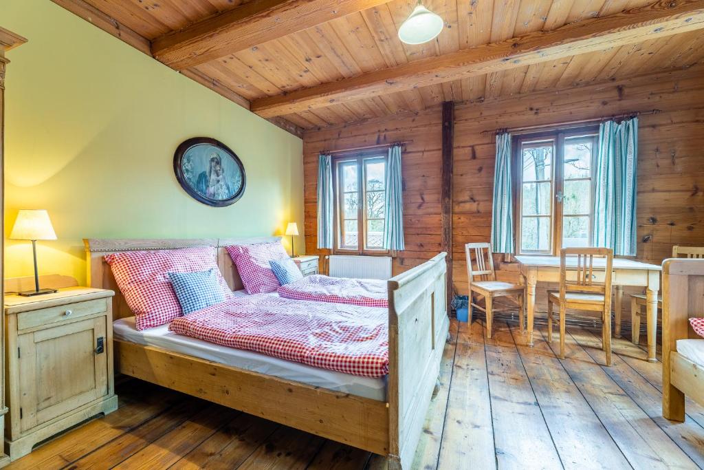 een slaapkamer met een bed en een tafel en stoelen bij Penzion a hostinec Kyjovská terasa in Krásná Lípa