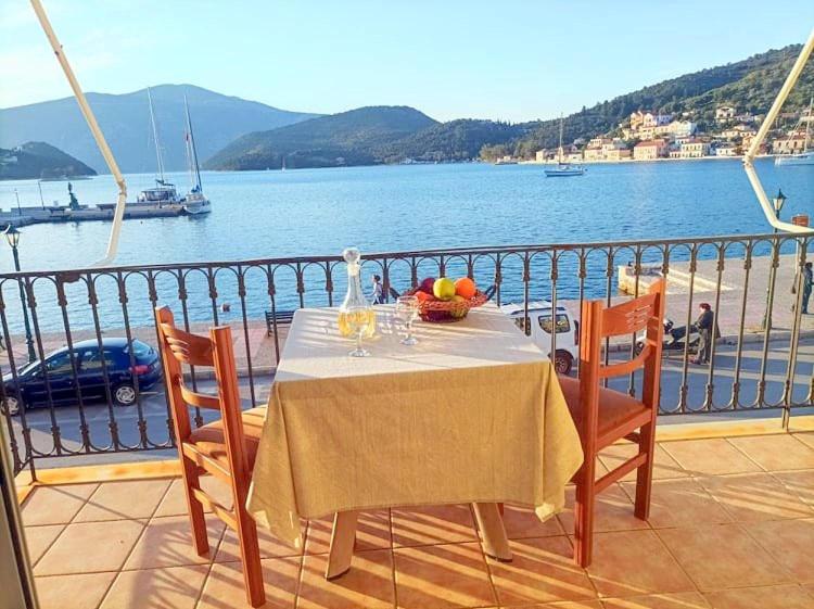 a table on a balcony with a view of the water at Lourantos Bayside Apartments in Vathi