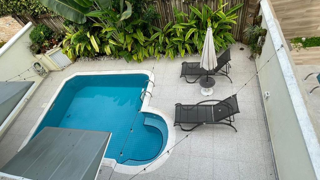 una vista sul soffitto di una piscina con sedie e ombrellone di Refúgio em Juquehy no centro a poucos metros do mar com piscina privativa aquecida a São Sebastião