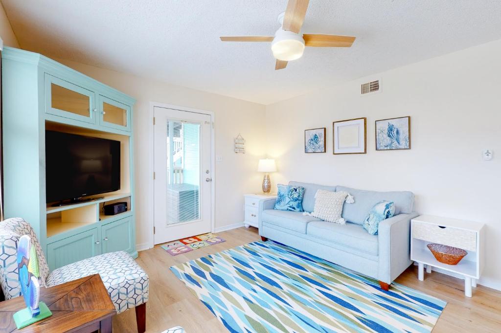 a living room with a couch and a tv at Lani Kai 130 in Gulf Shores