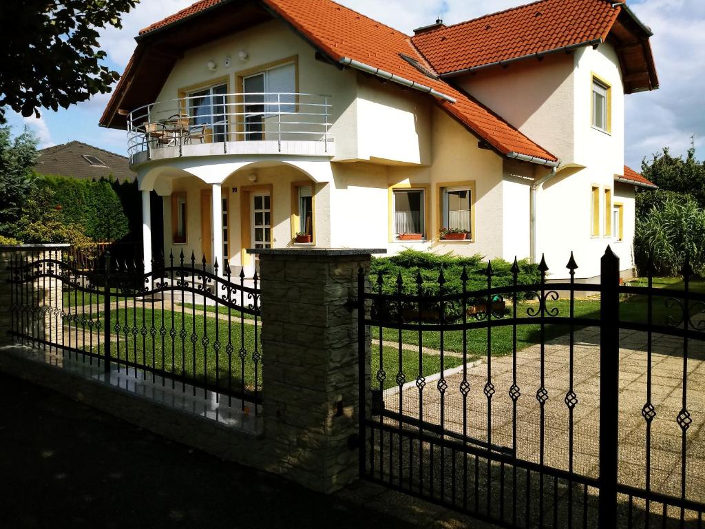 a house with a fence in front of it at Abigel Thermal Apartman in Bük