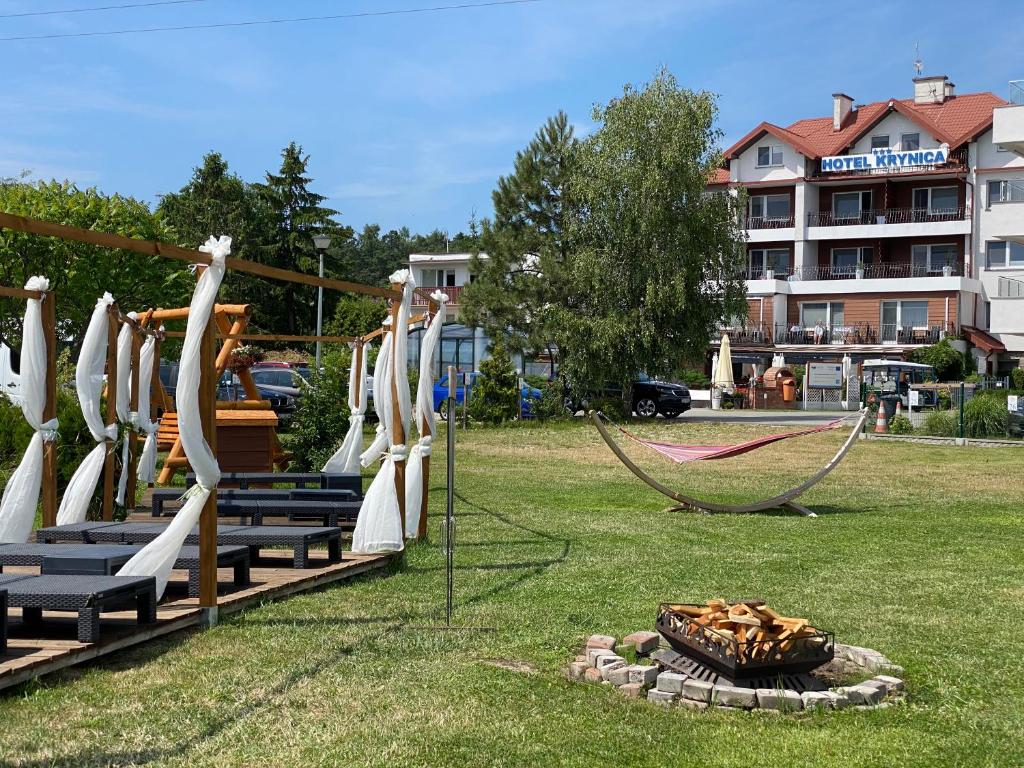 a park with a swing set and a fire pit at Hotel Krynica in Krynica Morska
