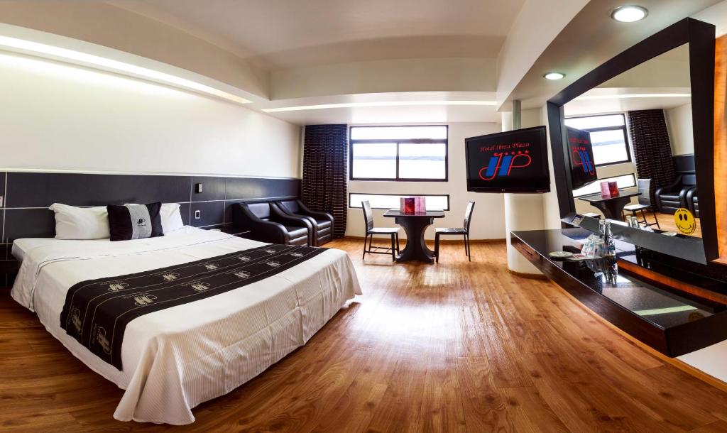 a hotel room with a bed and a flat screen tv at Hotel Ibiza Plaza in Mexico City