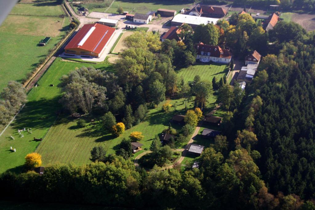 an aerial view of a farm with a field and trees at Heidegut Eschede Reitsportanlage und Feriendorf in Eschede