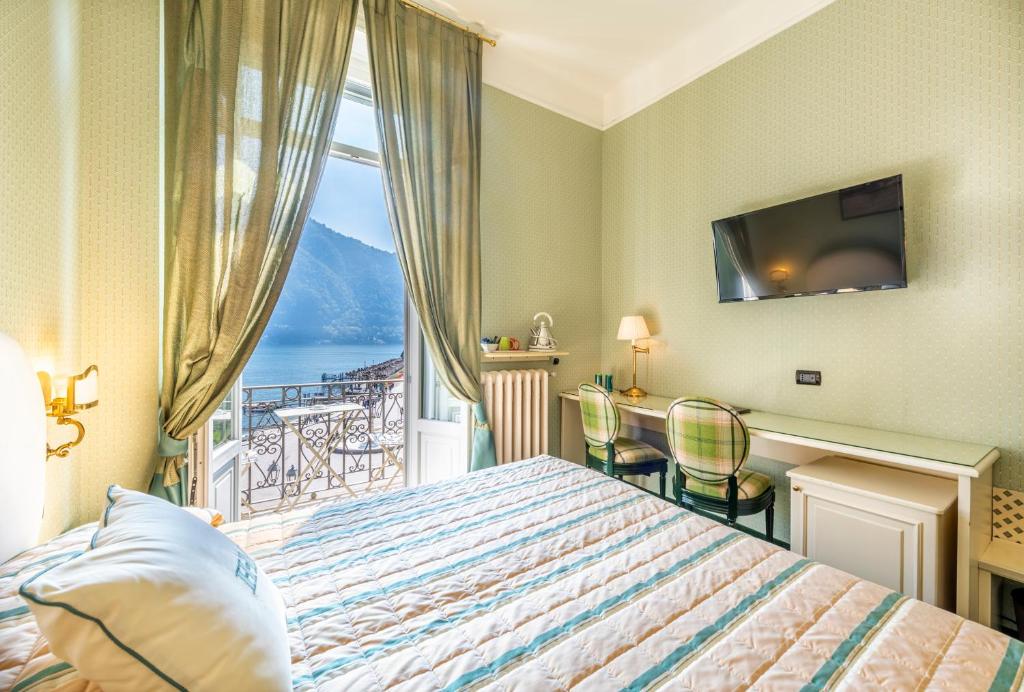 a hotel room with a bed and a view of the ocean at Hotel Miralago in Cernobbio