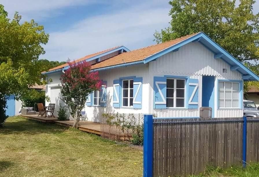 ein kleines blau-weißes Haus mit einem Zaun in der Unterkunft Maison ossature bois in Lège