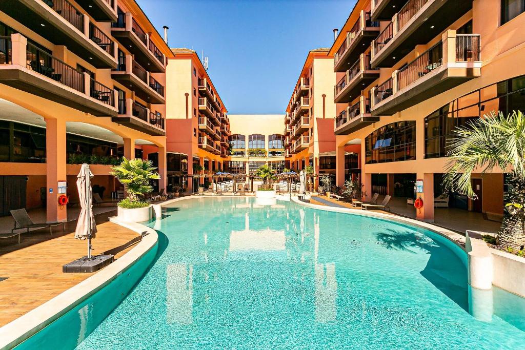 uma piscina no meio de um edifício em Resort pé na areia - Suítes JBVTOP em Florianópolis