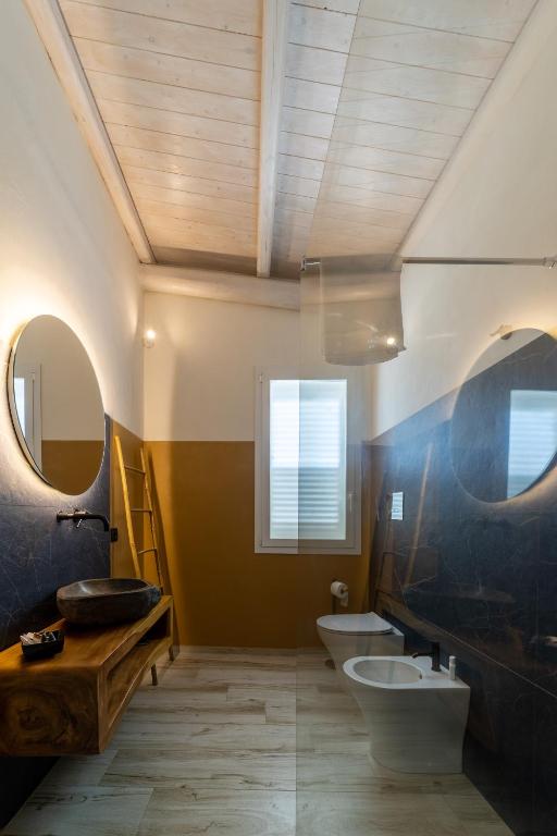 łazienka z 2 toaletami, umywalką i lustrem w obiekcie Villa White Luxury Residence w mieście Marsala