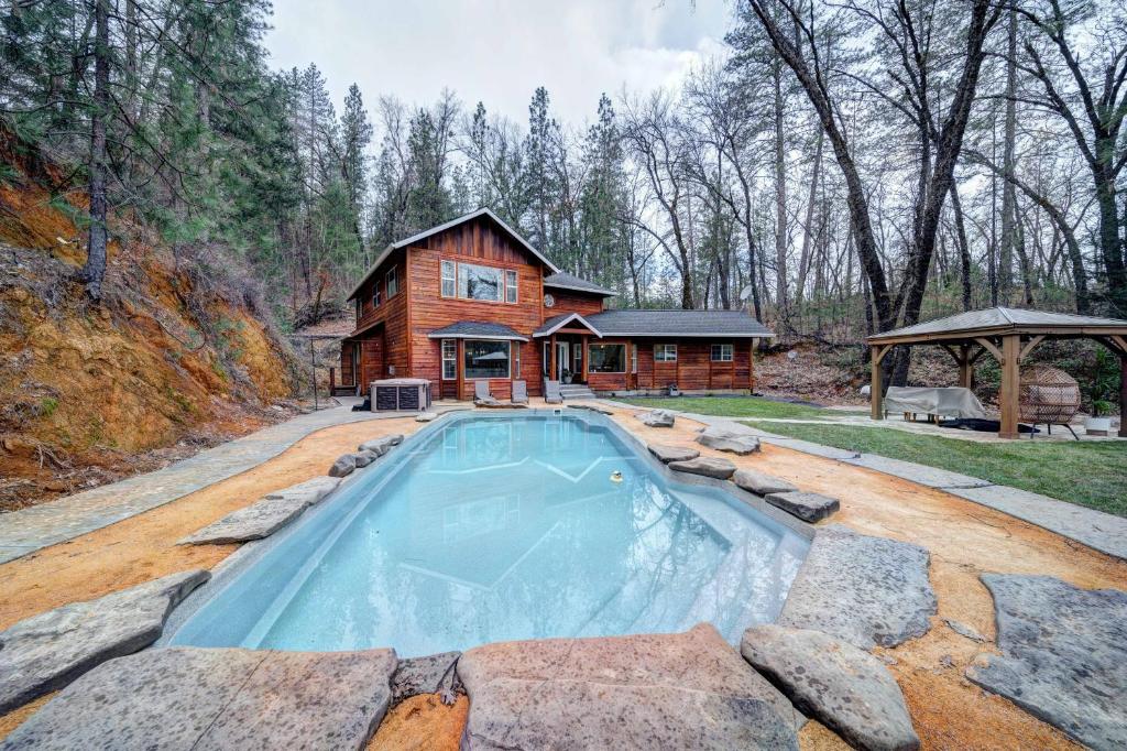 a log cabin with a pool in front of a house at Luxury Cabin at Lakehead in O'Brien