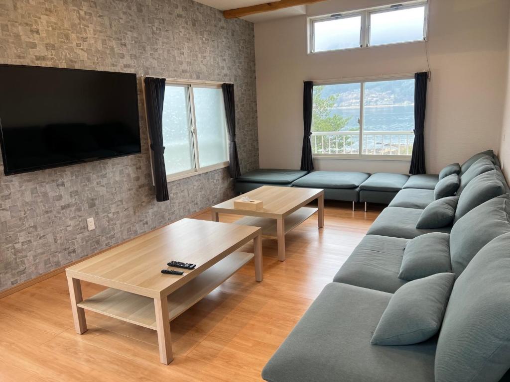 a living room with a couch and a flat screen tv at Koya TRIBE - Vacation STAY 48392v in Oishi