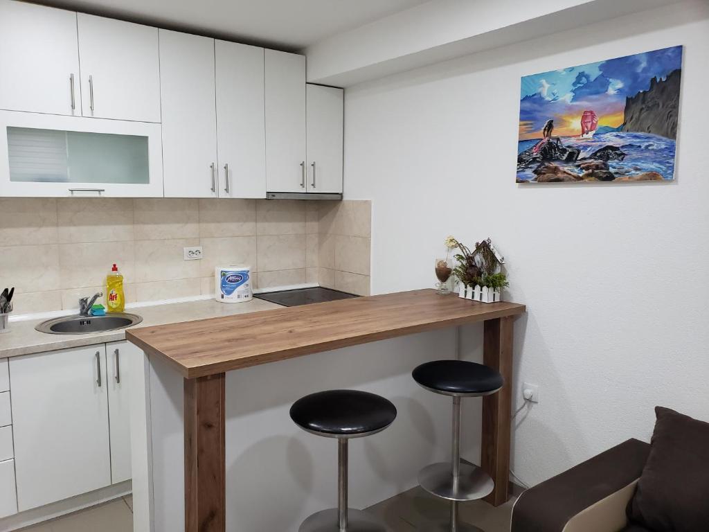 eine Küche mit einer Theke und Hockern in einem Zimmer in der Unterkunft Apartmani Pajic in Jagodina