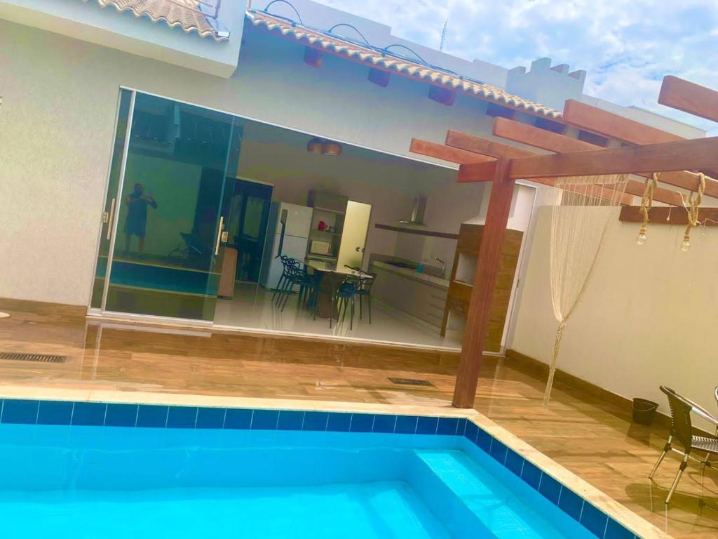 uma casa com piscina em frente a uma casa em Casa com piscina e duas suítes perto do Parque Lagoa Quente em Caldas Novas