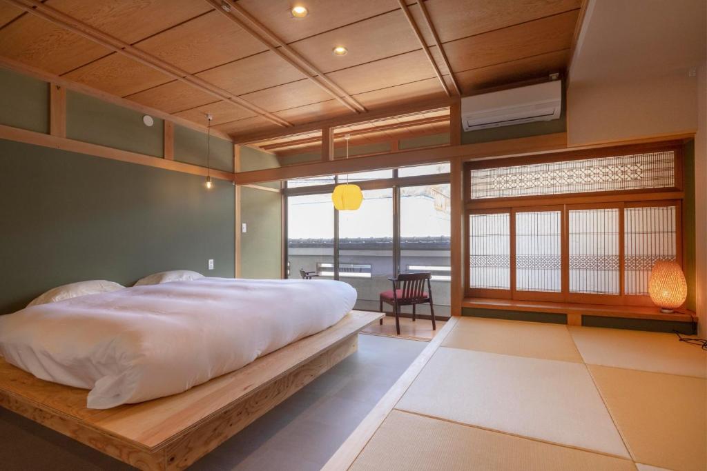 a bedroom with a large bed and a large window at Coliving & Cafe SANDO - Vacation STAY 26481v in Imabari