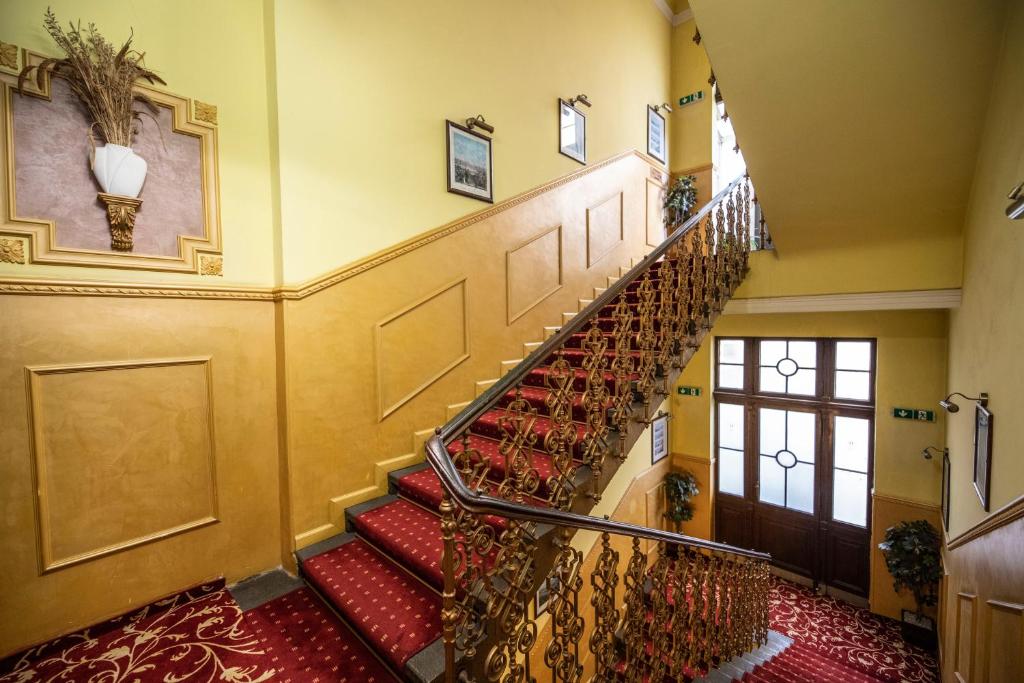 a spiral staircase in a building with red carpet at Old Prague Hotel in Prague
