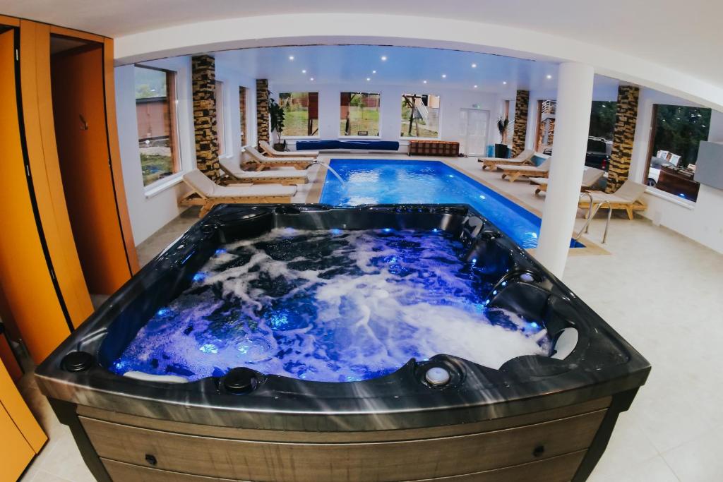 jacuzzi en una habitación con piscina en Wellness Resort Szécseny, en Jögödfürdő
