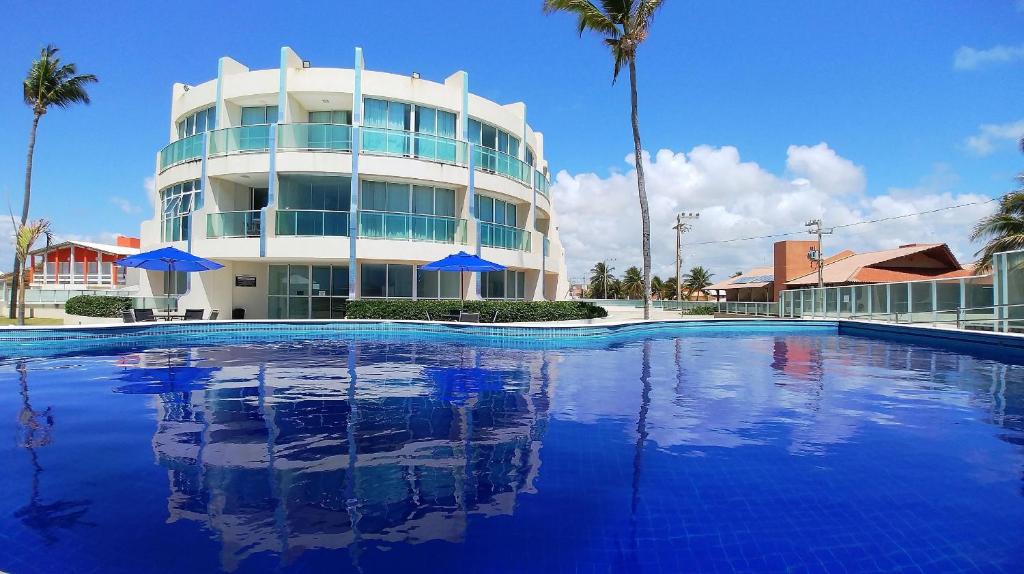 um edifício com piscina em frente a um edifício em Areias do Mar ! Confortável e com Ar na Sala A315 na Barra de São Miguel