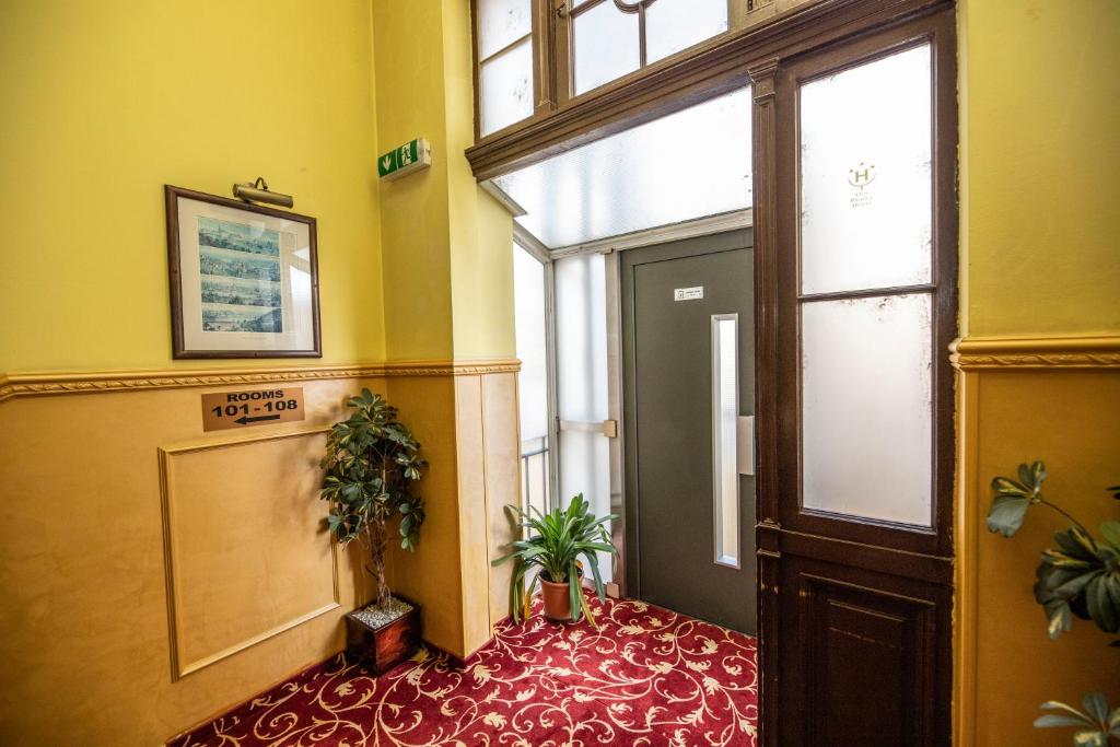 a hallway with a door and a room with plants at Old Prague Hotel in Prague