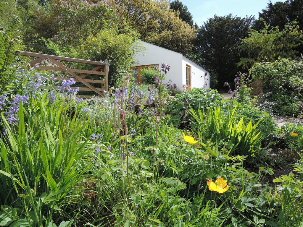 a garden with flowers in front of a building at Hadrian's Barn in Heddon on the Wall