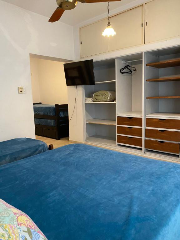 een slaapkamer met een bed en een tv en planken bij Departamento Hospital Privado Quality maternidad Con cochera in Cordoba
