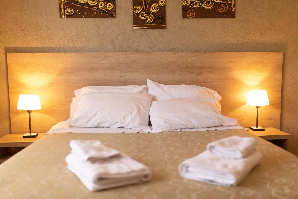 ein Bett mit zwei Handtüchern darauf mit zwei Lampen in der Unterkunft Apartamentos Boulevard II in San Rafael